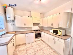 a kitchen with white cabinets and a microwave at Villa Marina - Inalko in Alcossebre