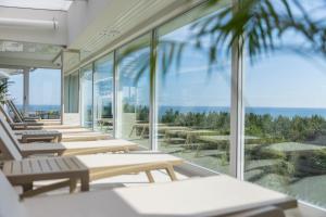 a row of chairs in a building with a view of the ocean at Maloves Resort & Spa in Władysławowo