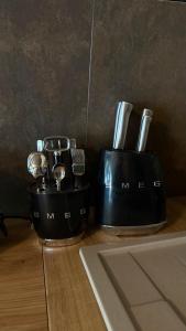 two kitchen utensils in black containers on a counter at AFRAME Solotvino in Solotvyno