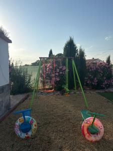 a playground with two swings and a swing set at CUEVA RURAL PALAPA DEL PERAL in El Charcón