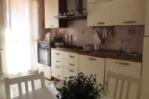 a kitchen with white cabinets and a table with a plant at Appartamento in Villa Nadin in Monte Compatri