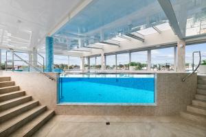 a swimming pool in a building with stairs at Maloves Resort & Spa in Władysławowo