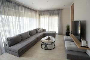 a living room with a couch and a table at Pearl Luxury Suites in Paralia Dionysiou
