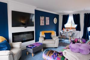 a living room with blue and white furniture and a table at Number 9 in Fort William