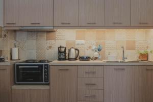 a kitchen with a stove and a microwave at The Beach House in Karistos