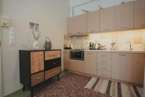 a kitchen with wooden cabinets and a sink and a microwave at The Beach House in Karistos