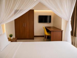a bedroom with a bed and a desk and a television at New Swanga in Nairobi