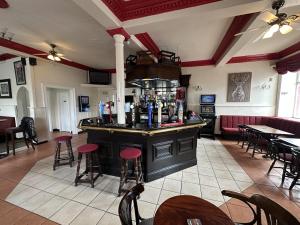 a bar in a restaurant with tables and chairs at Waverley Hotel in Bonnyrigg