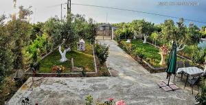 a garden with statues of trees and a house at Villa Meli in Sozopoli