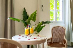 a table with two glasses of orange juice on it at lemasrocamour in Roquemaure