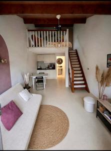 a living room with a white couch and a staircase at La Parenthèse Landaise Duplex rénové avec jardin & piscine in Saint-Julien-en-Born
