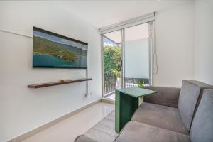 a living room with a couch and a large window at Hotel Santa Ana Medellin in Medellín