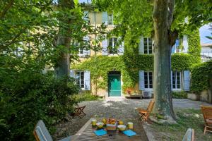a picnic table in front of a building with a green door at lemasrocamour in Roquemaure