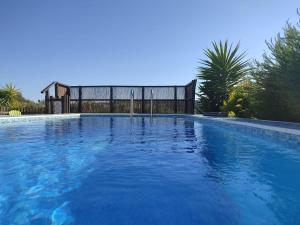 a large swimming pool with blue water at Casa da Lameira in Serra