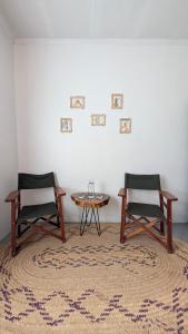 two chairs and a table in front of a white wall at Nomads nest safari house in Arusha +42 photos