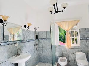 a bathroom with a sink and a toilet and a window at HappiCasaRD & Holistic House in Sosúa