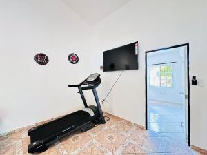 a room with a treadmill and a tv on the wall at HappiCasaRD & Holistic House in Sosúa