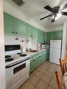 a kitchen with green cabinets and a white refrigerator at Dreamweavers Cottages and Vacation Homes in Rustico