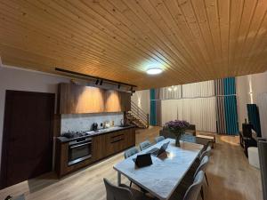 a living room with a table and a kitchen at DreamHouse in Cholpon-Ata