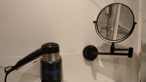 a hair dryer and a mirror on a wall at Hotel Chiquín in Tapia de Casariego