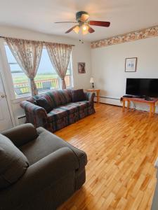a living room with a couch and a television at Dreamweavers Cottages and Vacation Homes in Rustico