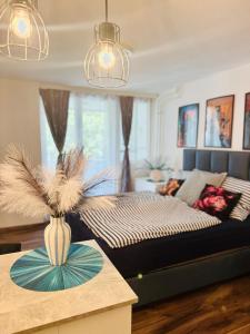 a living room with a bed and a vase on a table at Paloma Blanca 2 in Gárdony +31 photos