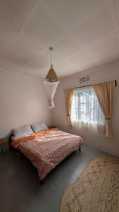 a bedroom with a bed and a window at Nomads nest safari house in Arusha
