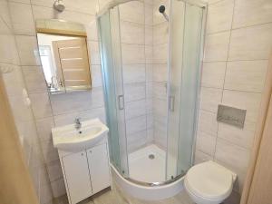 a bathroom with a shower and a toilet and a sink at Domki CLAUDIA in Darłowo +9 photos
