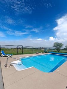 a swimming pool with a chair next to a fence at Dreamweavers Cottages and Vacation Homes in Rustico