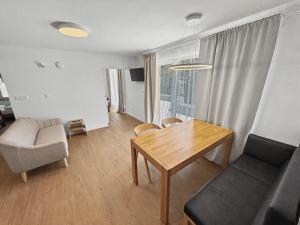 a living room with a dining room table and chairs at Wellness Apartmány Pastviny in Pastviny