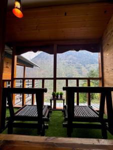 Zwei Bänke stehen auf der Veranda einer Hütte. in der Unterkunft Zoella in Gushaini + 33 Fotos