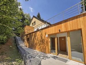 a house with glass doors on the side of it at Wellness Apartmány Pastviny in Pastviny