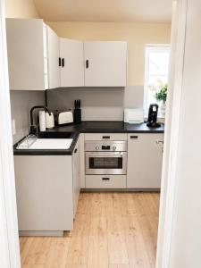 a white kitchen with white cabinets and a wooden floor at MeinZuhause Apartmente NG in Bad Pyrmont