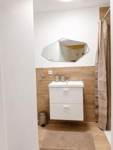 a bathroom with a white sink and a mirror at MeinZuhause Apartmente NG in Bad Pyrmont