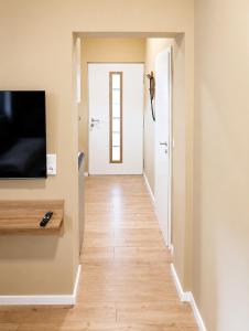 a hallway with a white door and a television on a wall at MeinZuhause Apartmente NG in Bad Pyrmont