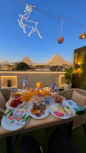 a table with plates of food on it with a view at Leeda Pyramids View in Cairo
