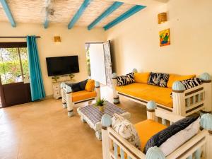 a living room with a couch and a tv at Tropical Court 2 BedroomDiani Beach villa in Kwale