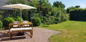 a table with an umbrella on a patio at Fewo Mandelsloh in Neustadt am Rübenberge
