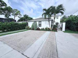 a white house with a palm tree and a driveway at Quiet retreat near Coconut Grove free parking in Miami