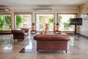 a living room with two couches and a flat screen tv at Rede Andrade Aquarius in Porto Velho