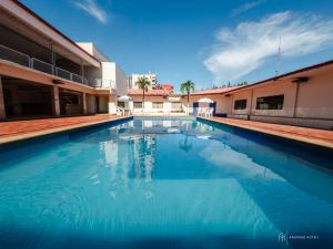 a swimming pool with blue water in a building at Rede Andrade Aquarius in Porto Velho