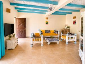 a living room with a couch and a tv at Tropical Court 2 BedroomDiani Beach villa in Kwale