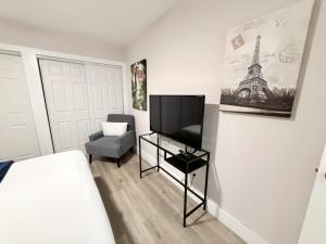 a bedroom with a bed and a tv and a chair at Quiet retreat near Coconut Grove free parking in Miami