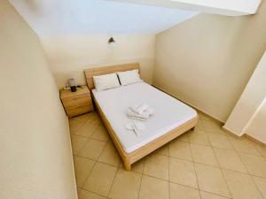 a small bedroom with a bed with two shoes on it at Feel free in Paleo Tsifliki