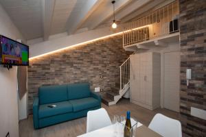 a living room with a blue couch and a brick wall at AL 54 Accommodation - Premium in San Benedetto del Tronto