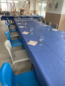 a long table in a room with blue tables and chairs at Hotel Chiquín in Tapia de Casariego