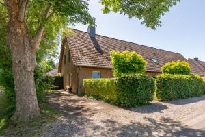 a house with hedges in front of a building at Hjertets Hus in Humptrup