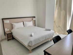 a bedroom with a bed with a table and chairs at Le Clos de Sangonis in Saint-André-de-Sangonis