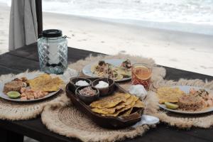 a table with plates of food on a table near the beach at UNÚ Beach Hotel in Palomino