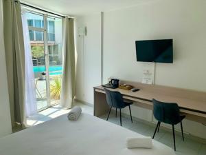 a room with a bed and a desk with two chairs at Le Clos de Sangonis in Saint-André-de-Sangonis